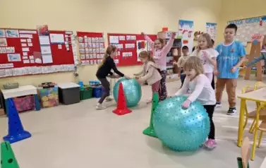 toczenie piłki przez dzieci między pachołkami