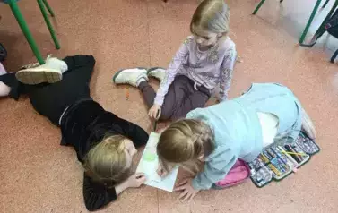 uczennice i uczniowie wykonują książki 