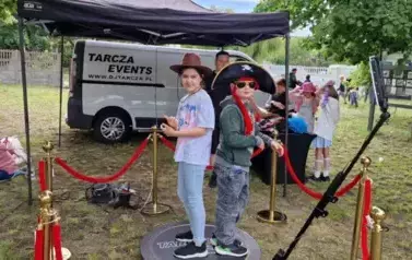 dziewczynka i chłopiec w przebraniach w fotobudce