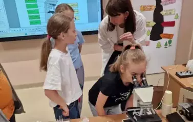 uczniowie oglądają mikroorganizmy pod mikroskopem