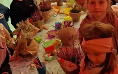 dzieci tworzą kompzycje z wrzos&oacute;w