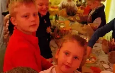 dzieci tworzą jesienne kompzycje z wrzos&oacute;w