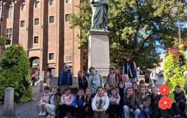 Uczniowie klasy 2A przed pomnikiem Mikołaja Kopernika w Toruniu
