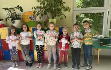 uczniowie_klasy drugiej pozujący do zdjęcia z flagami Wielkiej Brytani w kształcie serca