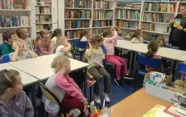 pani bibliotekarka pokazuje dzieciom książkę