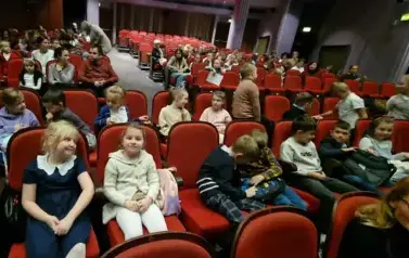 Uczniowie klasy 1c i 1d siedzą na widowni w teatrze