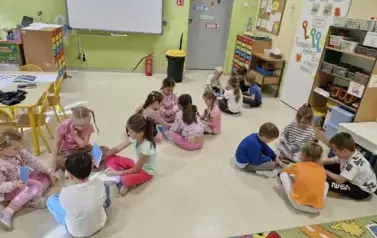 dzieci w grupach układają puzzle przedstawiające drzewa w r&oacute;żnych porach roku