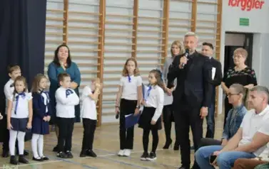 Prezydent Miasta m&oacute;wi do mikrofonu a obok stoją zgromadzeni goście