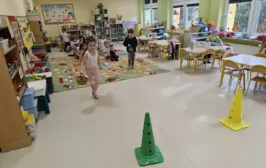 dzieci na wyścigi zbierają kasztany do koszyk&oacute;w