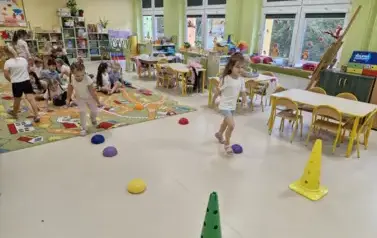dzieci w rzędach skaczą po kamieniach sensorycznych 