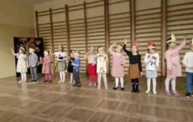dzieci prezentują przed gośćmi piosenkę Przyszła jesień do parku