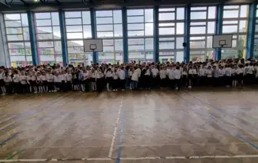 uczniowie klas 1 - 8 zgromadzona w sali gimnastycznej podczas śpiewania hymnu