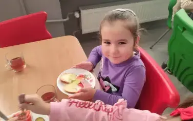 przedszkolak na stoł&oacute;wce sam układa kanapkę na talerzu