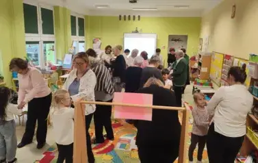 seniorzy i przedszkolaki w sali bawią się wsp&oacute;lnie w zabawę nie chcę cię