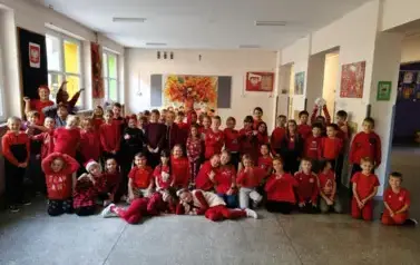 Uczniowie szkoły na korytarzu ubrani w czerwoną odzież