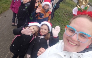 Grupa pierwszoklasist&oacute;w i trzecioklasist&oacute;w wraz z opiekunami w świątecznych czapkach i rogach renifera
