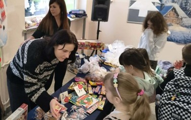 Zdjęcie przedstawia nauczycielki sprzedające gadżety podczas kiermaszu