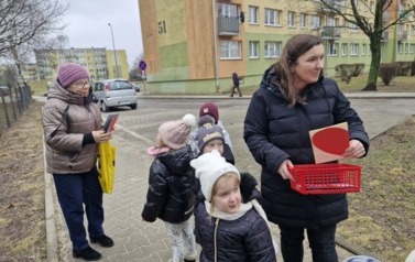 dzieci wręczają walentynki mieszkańcom osiedla