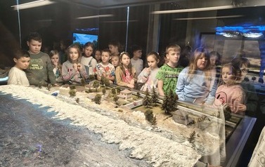 Uczniowie 2b oglądają makietę przedstawiającą tsunami idące na miasto
