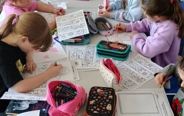 Dziewczynki z Koła Bibliotecznego rozwiązujące karty pracy