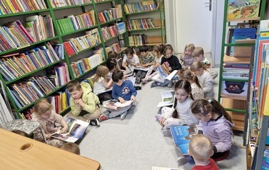 Dzieci w bibliotece oglądają książki o Polsce