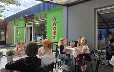 Dzieci zajadają lody w cukierni Szarlotka