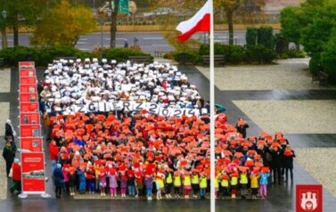 Uczniowie, dzieci z przedszkoli  i młodzież z innych szk&oacute;ł tworząca ŻYWĄ FLAGĘ