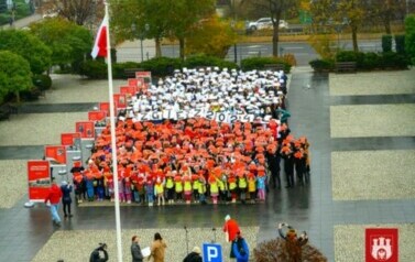 Uczniowie, dzieci z przedszkoli  i młodzież z innych szk&oacute;ł tworząca ŻYWĄ FLAGĘ
