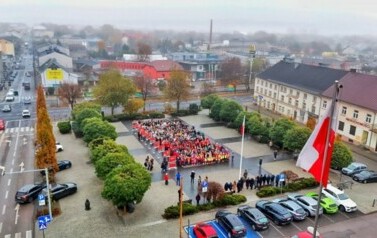Uczniowie, dzieci z przedszkoli  i młodzież z innych szk&oacute;ł tworząca ŻYWĄ FLAGĘ