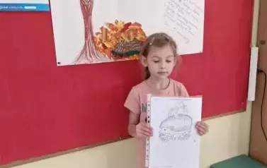 Dziewczynka z prezentacją o jeżu