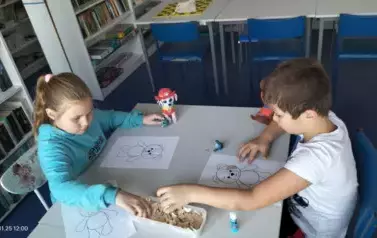 Dzieci wyklejają misia