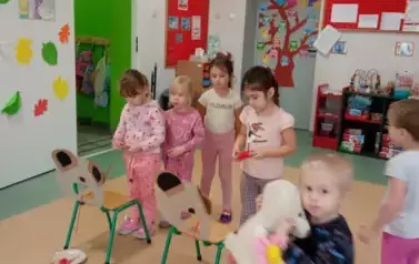 dzieci nawijają wełnę na szpulkę 