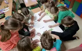 Dzieci pracują w grupie nad plakatem