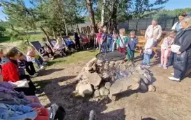 dzieci siedzą przy ognisku