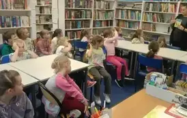pani bibliotekarka pokazuje dzieciom książkę