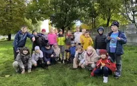 Dzieci z klasy 2c stoją przy posadzonej jabłoni