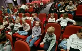 Grupa uczni&oacute;w siedząca na widowni