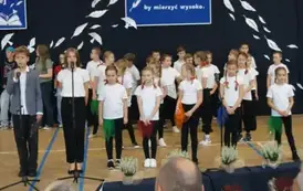 uczniowie prowadzący uroczystość na tle uczni&oacute;w klasy trzeciej