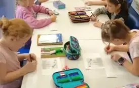 Dziewczynki z klas pierwszych tworzące zakładki do książek na zajęciach Szkolnego Koła Bibliotecznego