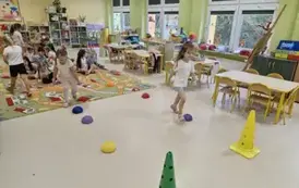 dzieci w rzędach skaczą po kamieniach sensorycznych 