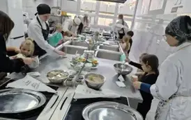 dzieci wybierają łyżkami serek z pojemniczk&oacute;w do misek