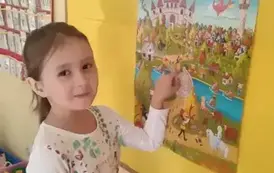 dziewczynakw wskazuje psotać bajkową na plakacie