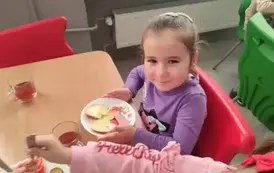 przedszkolak na stoł&oacute;wce sam układa kanapkę na talerzu