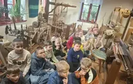uczniowie słuchają opowieści o dawnych metodach tworzenia tkanin