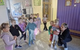 Przedszkolaki wręczają laurkę szkolnej babci