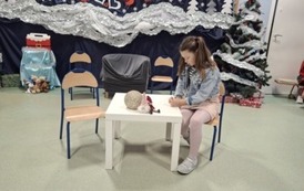 Uczennica z klasy 2A występująca w roli dziewczynki piszącej list do Świętego Mikołaja podczas inscenizacji dla babć i dziadk&oacute;w