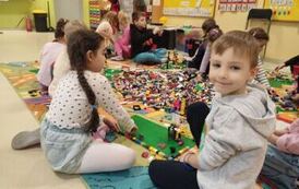 przedszkolak pokazuje swoją budowlę z klock&oacute;w lego