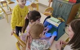 przedszkolaki obserwują swoje ręce pod lampą UV