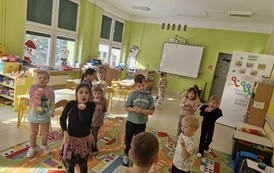Dzieci ćwiczą prawidłowy oddech dmuchajac w pi&oacute;rka