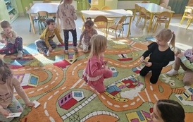 Dzieci losują kartonik z literą do zabawy Słowo na literkę